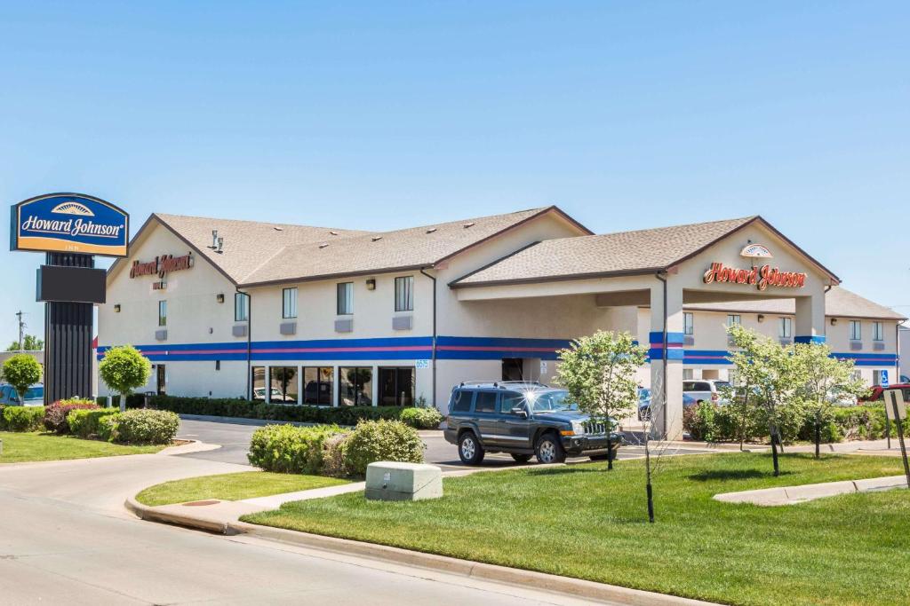 un edificio con un camion parcheggiato di fronte di Howard Johnson by Wyndham Wichita Airport a Wichita