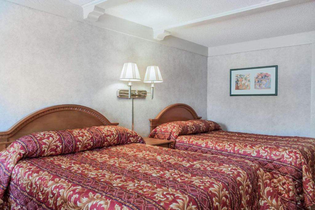 a hotel room with two beds and two lamps at Sunrise Inn in Elkton