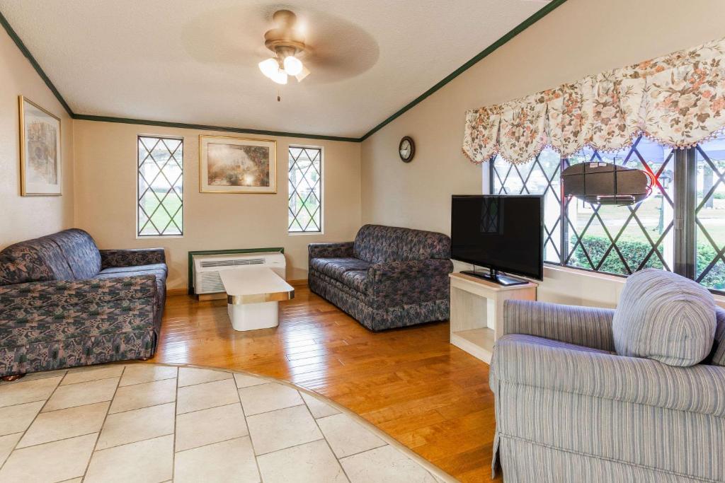 a living room with couches and a flat screen tv at Knights Inn Farmington Hills in Farmington Hills