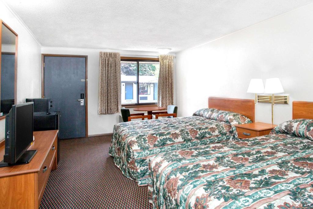 a hotel room with two beds and a flat screen tv at Knights Inn Pittston in Pittston