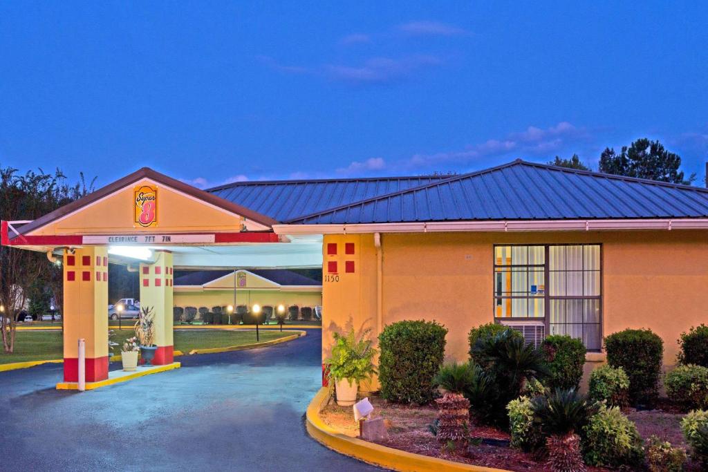 a hotel with a gas station at night at Super 8 by Wyndham Chipley in Chipley