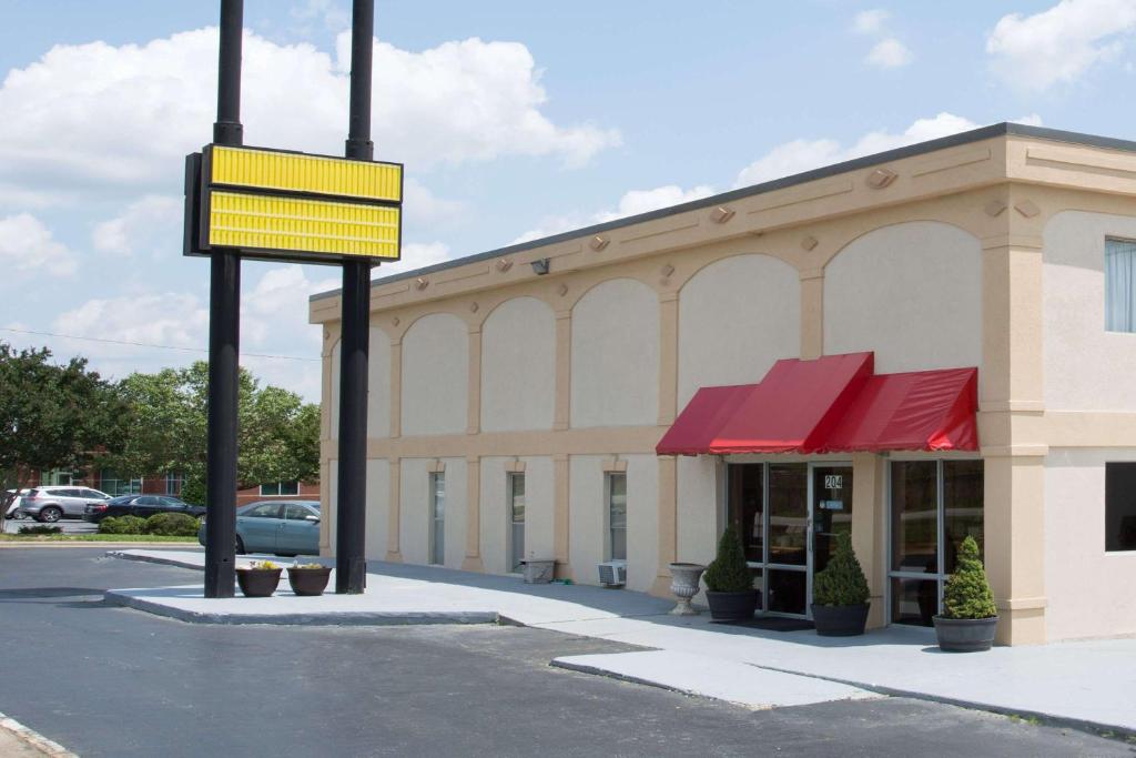 a building with a yellow sign in front of it at Super 8 by Wyndham Greensboro in Greensboro