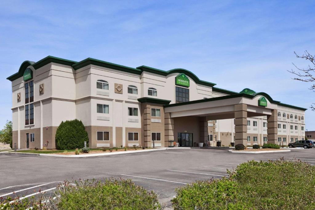 a large building with a parking lot in front of it at Wingate by Wyndham Pueblo in Pueblo