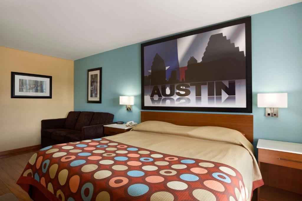 a hotel room with a bed and a large screen at Super 8 by Wyndham Austin Downtown/Capitol Area in Austin