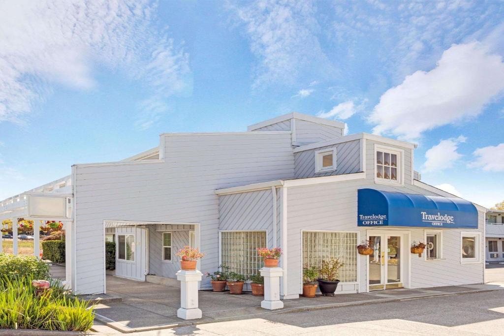 un edificio blanco con toldo azul en Travelodge by Wyndham Mill Valley/Sausalito, en Mill Valley