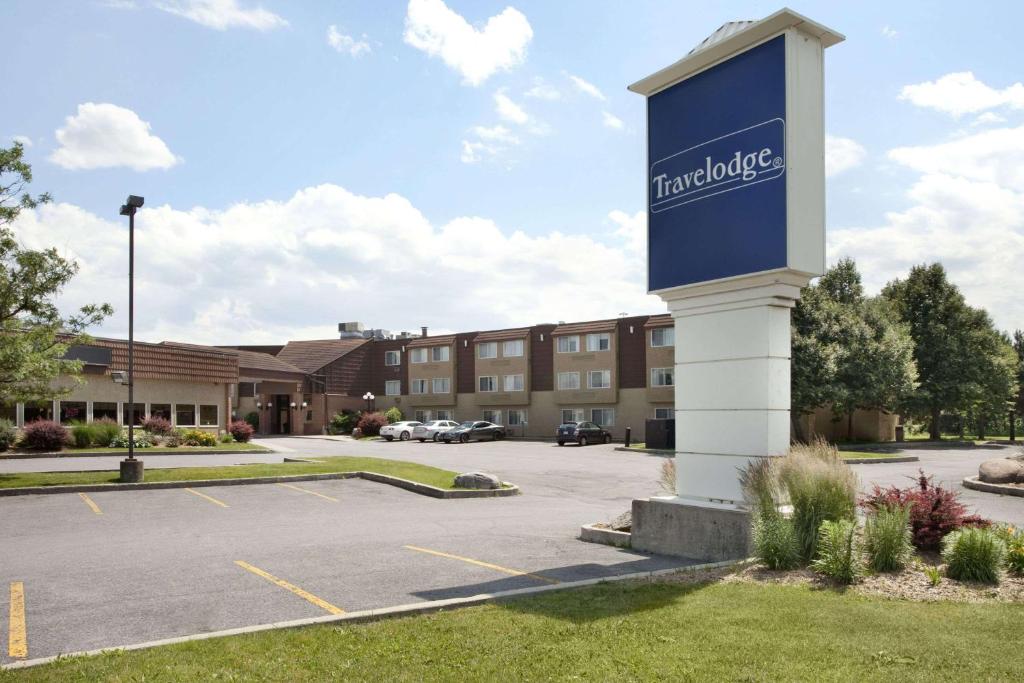 ein Schild für ein Hotel auf einem Parkplatz in der Unterkunft Travelodge by Wyndham Ottawa East in Ottawa