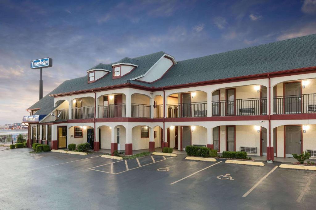 a hotel with a parking lot in front of it at Travelodge Inn & Suites by Wyndham Norman in Norman