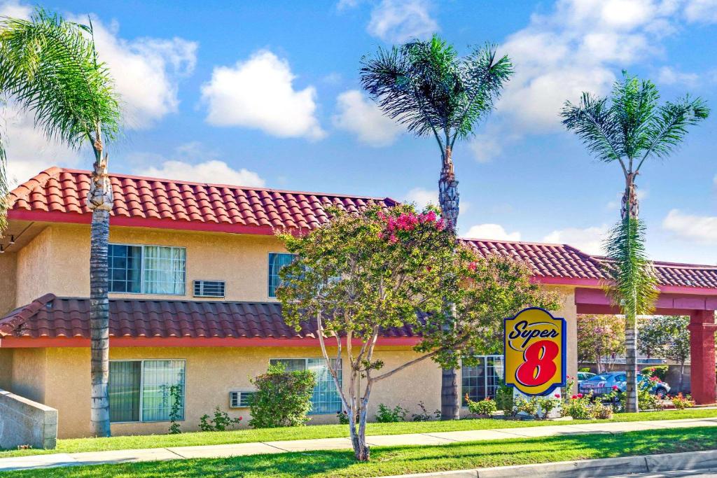 a restaurant with palm trees in front of it at Super 8 by Wyndham Upland Ontario CA in Upland