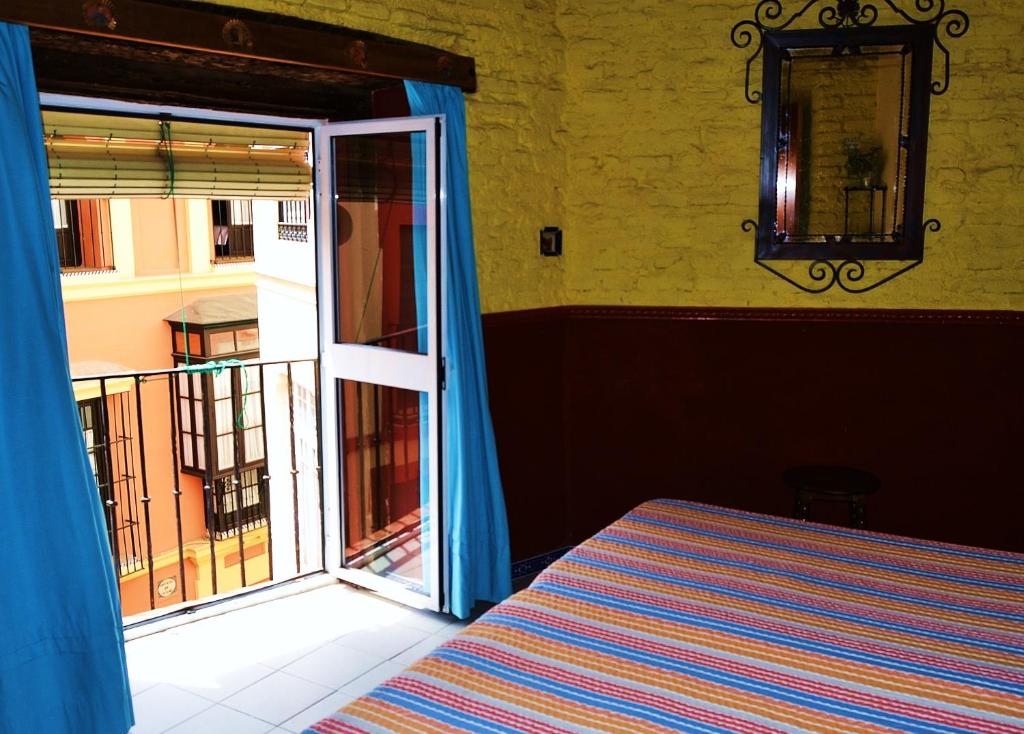 1 dormitorio con 1 cama y puerta corredera de cristal en PENSION VERGARA , Sevilla, en Sevilla