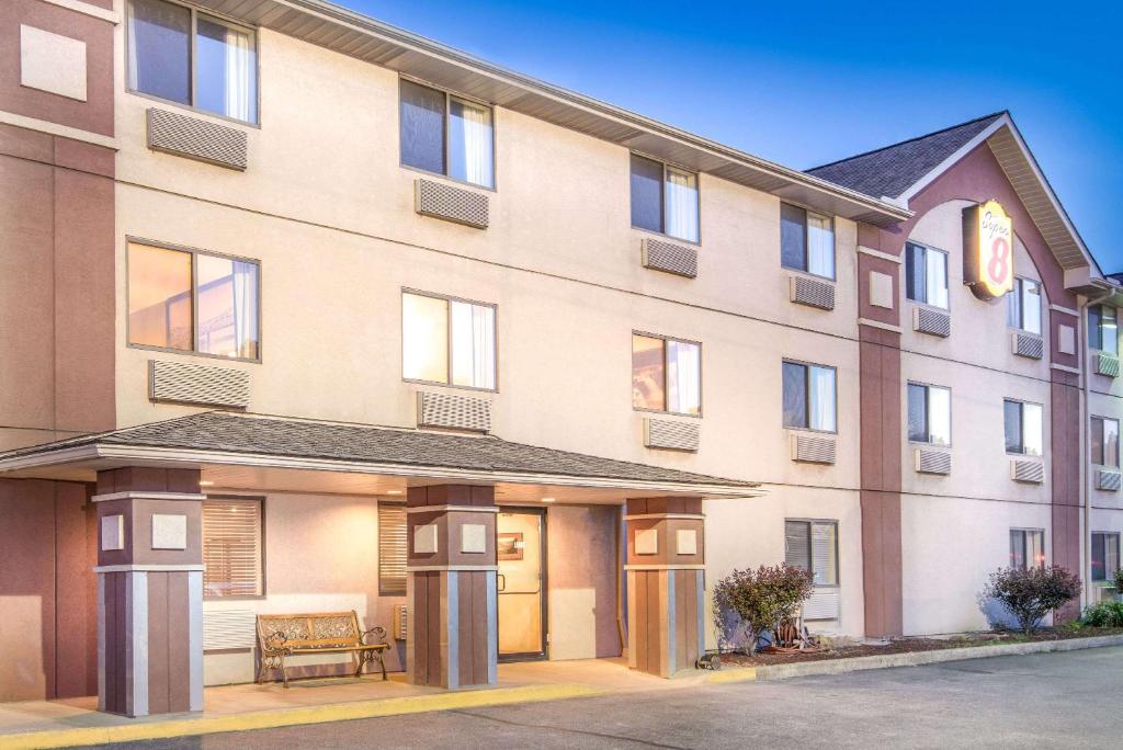 an apartment building with a bench in front of it at Super 8 by Wyndham Wheeling Saint Clairsville OH Area in Wheeling