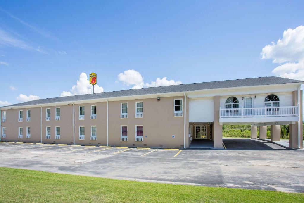 un gran edificio bronceado con una bandera en la parte superior en Super 8 by Wyndham Manning en Manning