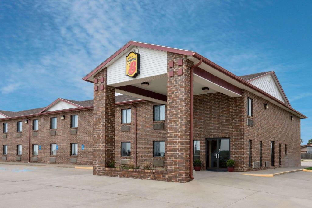 a large brick building with a sign on it at Super 8 by Wyndham Wakeeney in WaKeeney