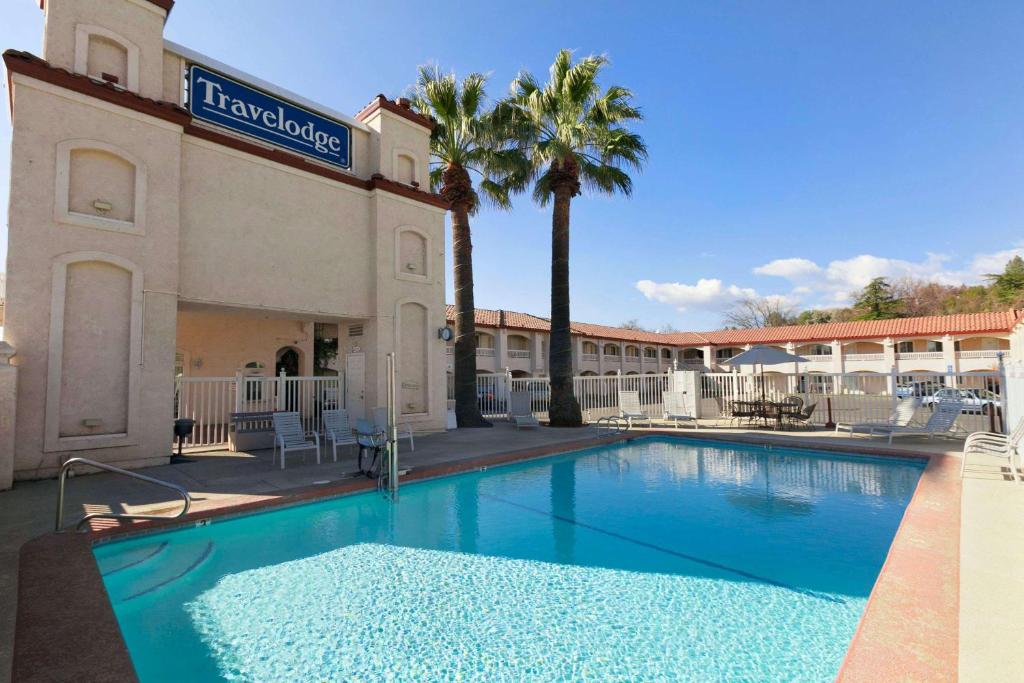 a large swimming pool in front of a hotel at Travelodge by Wyndham Redding CA in Redding
