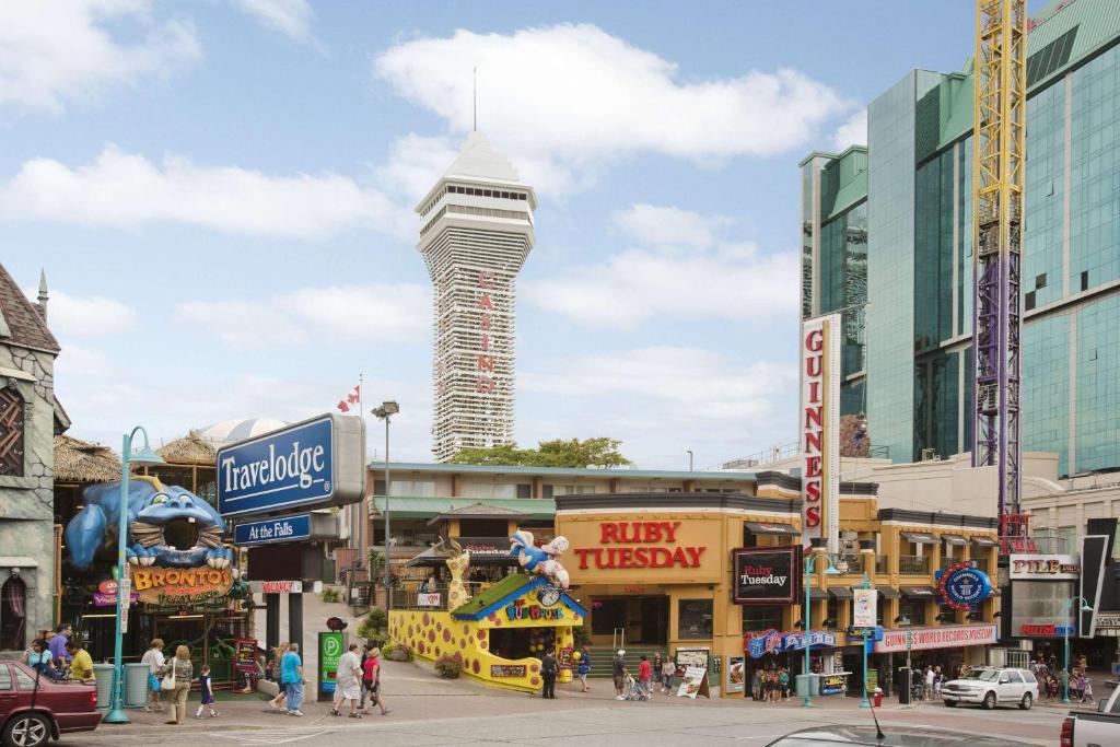 una concurrida calle de la ciudad con una torre alta en el fondo en Travelodge by Wyndham Niagara Falls At the Falls, en Niagara Falls