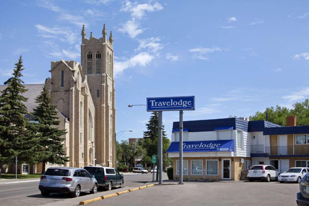 ein Straßenschild vor einem Gebäude mit einer Kirche in der Unterkunft Travelodge by Wyndham Moose Jaw in Moose Jaw