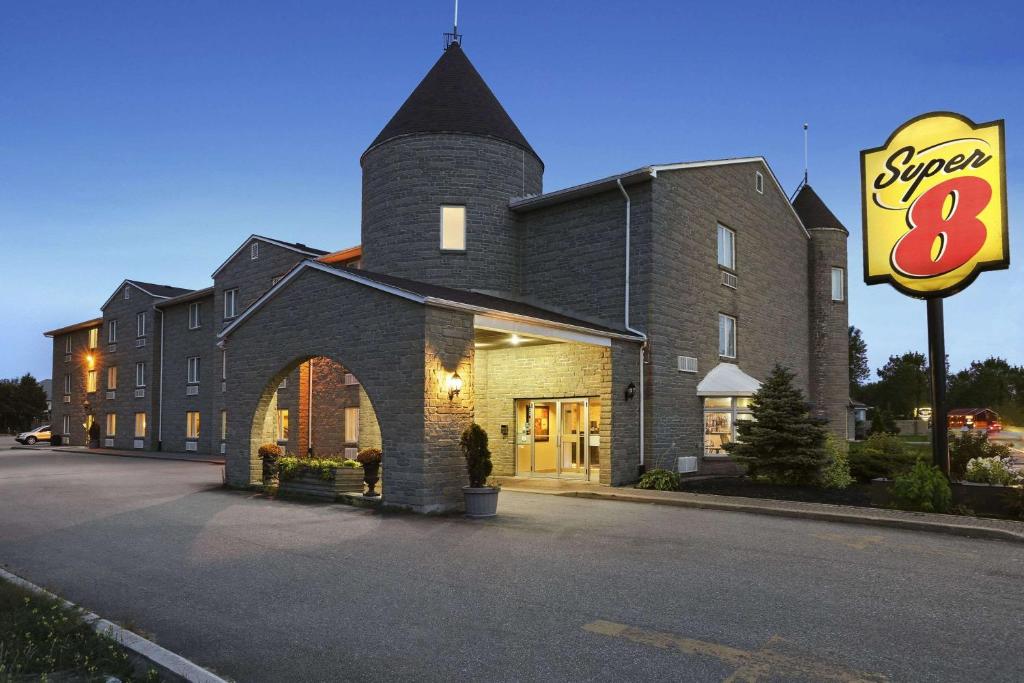 een groot bakstenen gebouw met een bord ervoor bij Super 8 by Wyndham North Bay in North Bay