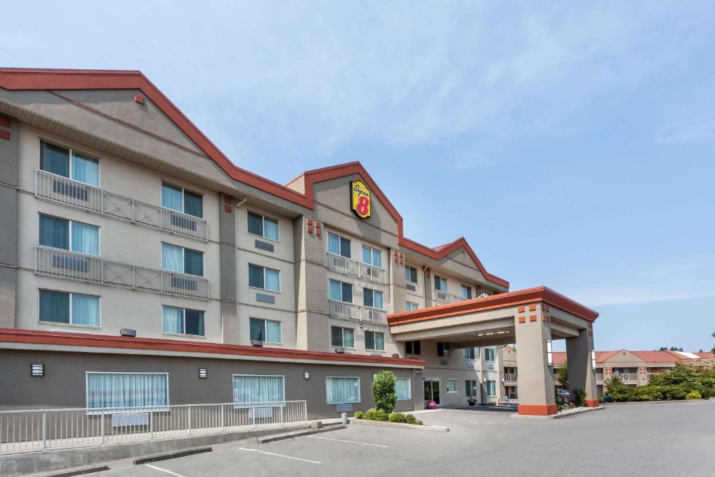 un hotel con un edificio con un reloj en él en Super 8 by Wyndham Abbotsford BC en Abbotsford