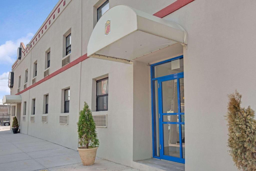 a building with a blue door on the side of it at Super 8 by Wyndham Long Island City LGA Hotel in Queens