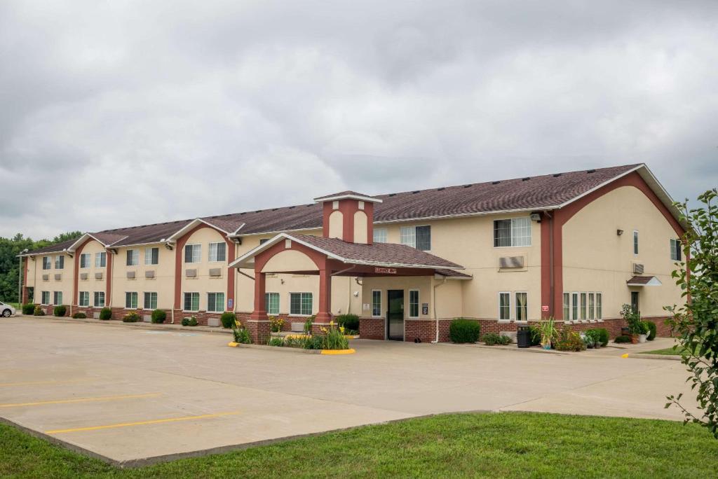 a large apartment building with a parking lot at Super 8 by Wyndham Mt. Carmel IL in Mount Carmel