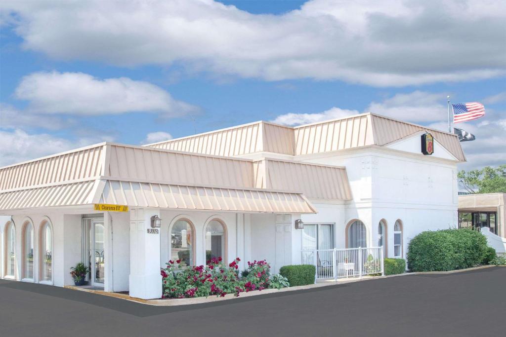 a rendering of a white building with an american flag at Super 8 by Wyndham Morton Grove/Chicago in Morton Grove