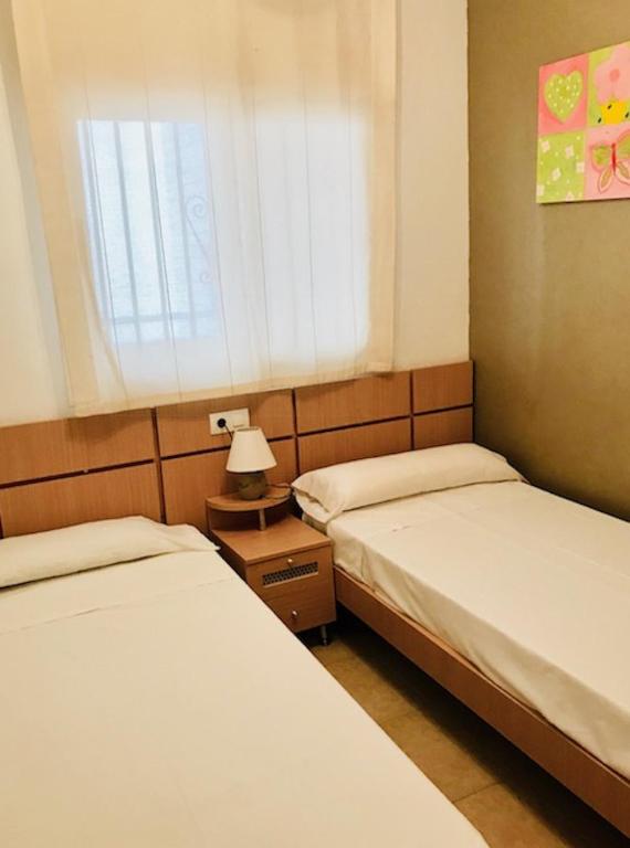 dwa łóżka w pokoju z oknem w obiekcie Apartamentos Boutique Valparaiso w mieście Oropesa del Mar