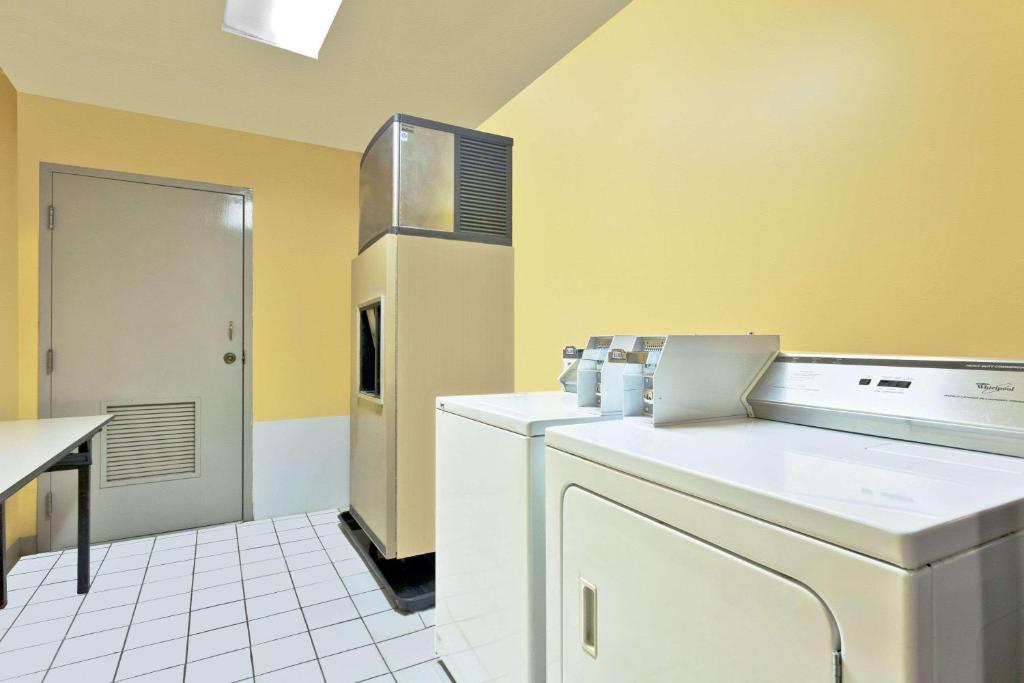 a kitchen with yellow walls and a refrigerator at Super 8 by Wyndham Franklin Hwy 31 in Franklin