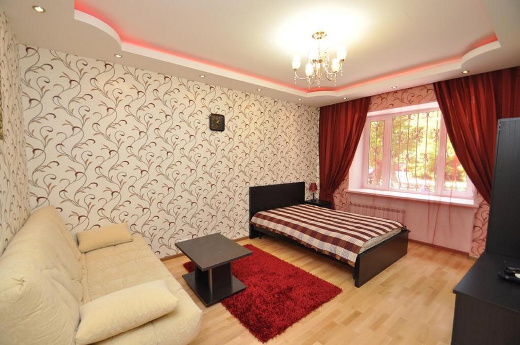 モスクワにあるApartment on Serpuhovskayaのリビングルーム(ベッド1台、赤い敷物付)