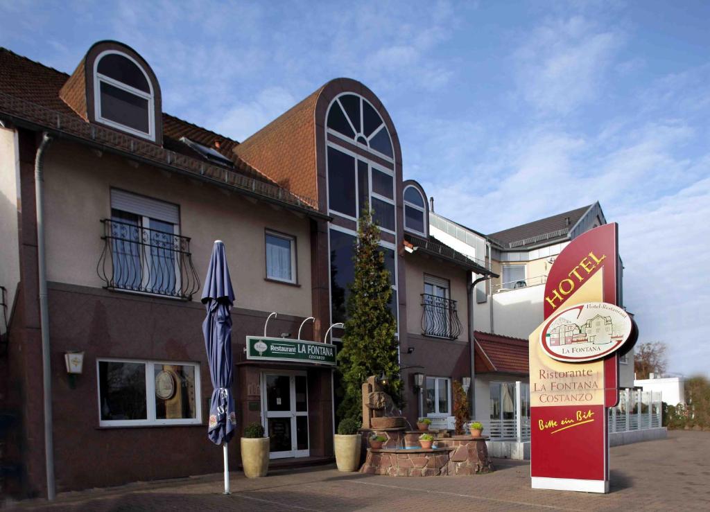 a building with a sign in front of it at Hotel-Restaurant La Fontana Costanzo in Sankt Ingbert