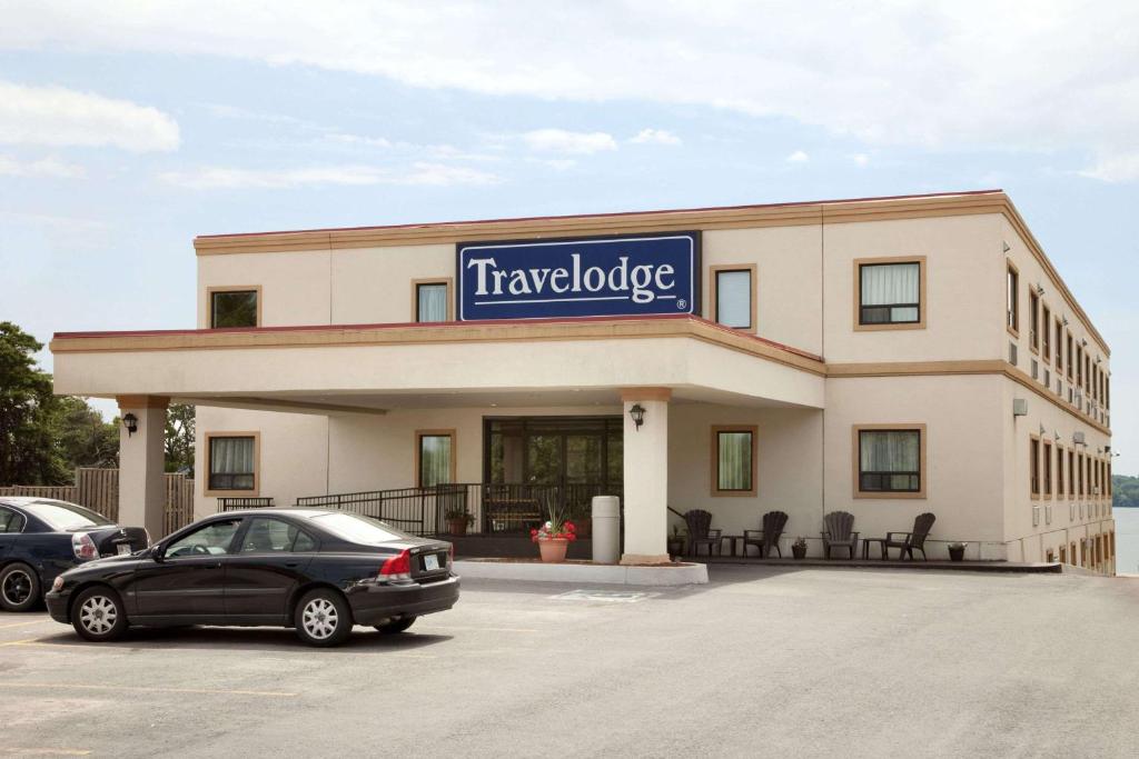 a car parked in a parking lot in front of a building at Travelodge by Wyndham Trenton in Trenton