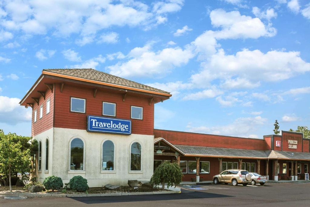 a building with a sign on the side of it at Travelodge by Wyndham Pioneer Villa in Halsey