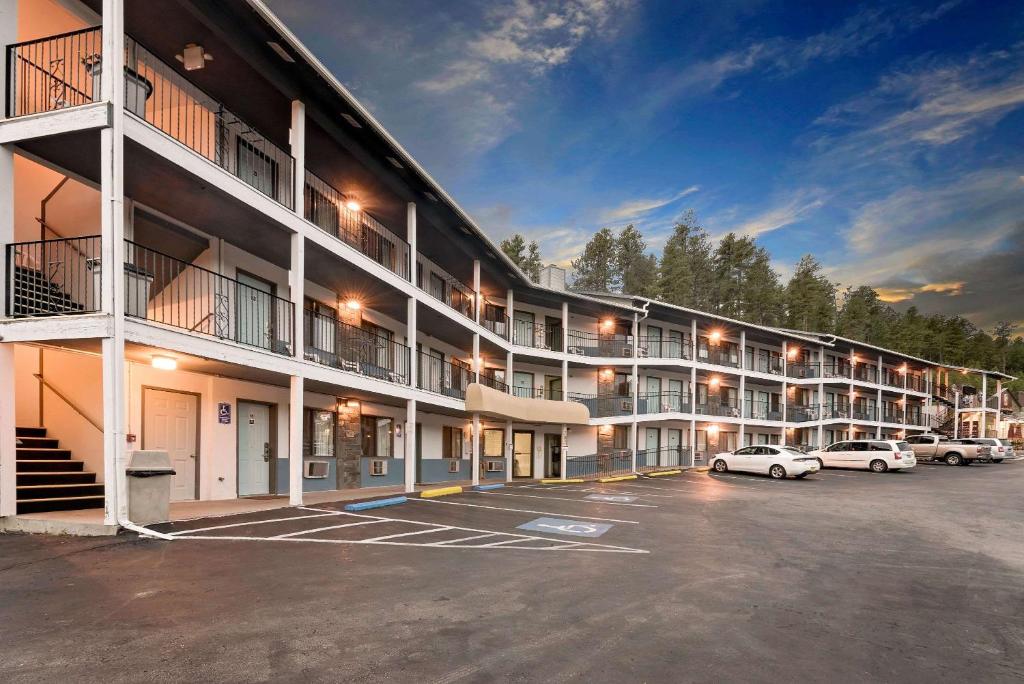 ein großes Apartmenthaus mit Autos auf einem Parkplatz in der Unterkunft Super 8 by Wyndham Keystone/Mt. Rushmore in Keystone