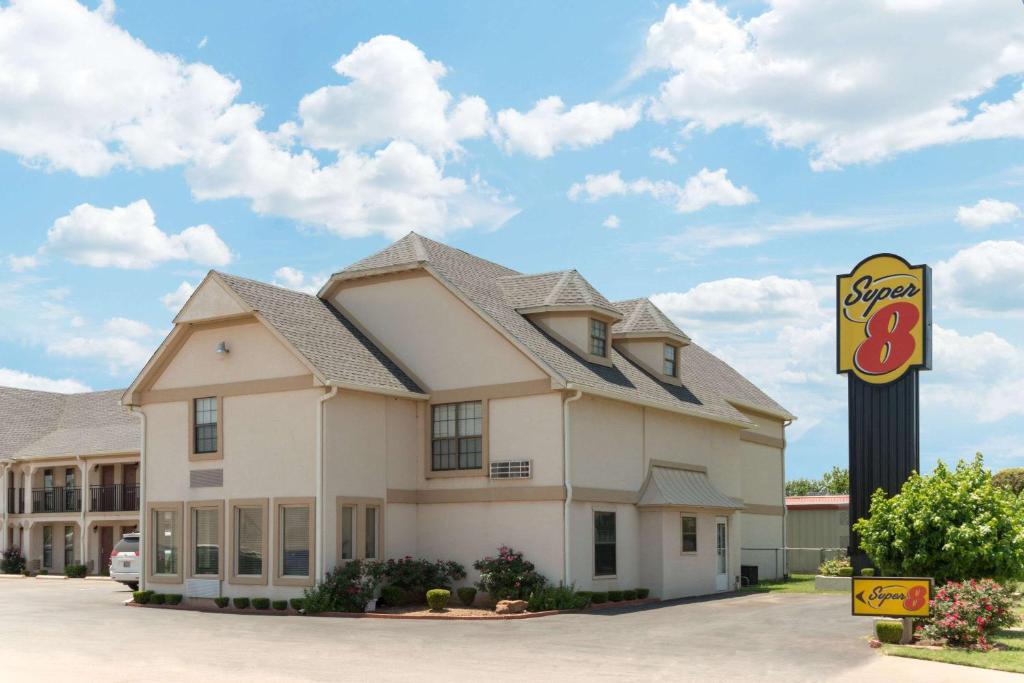 a hotel with a sign in front of it at Super 8 by Wyndham Enid in Enid