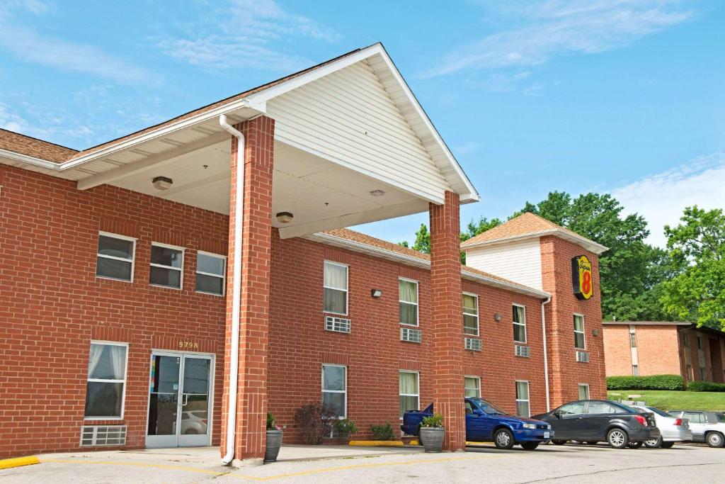 a red brick building with a white roof at Super 8 by Wyndham St. Louis Airport in Woodson Terrace