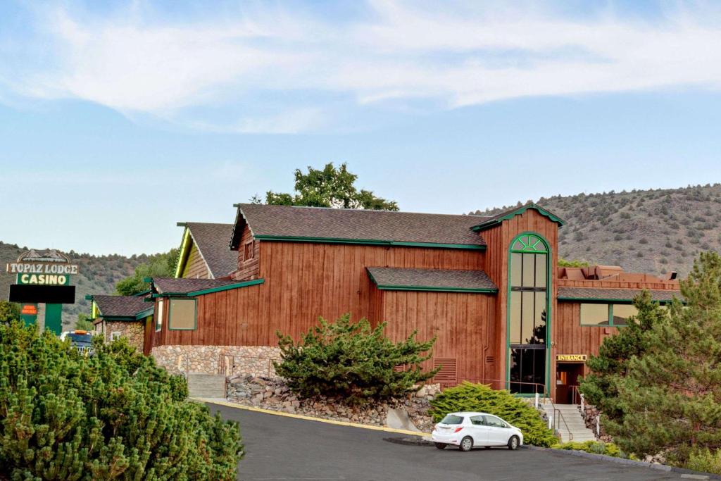 a large wooden building with a car parked in front at Topaz Lodge in Gardnerville