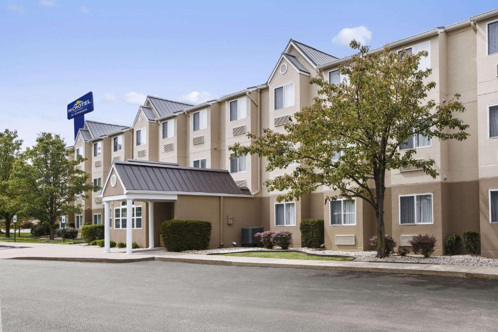 a building with a parking lot in front of it at Microtel Inn By Wyndham Louisville East in Louisville