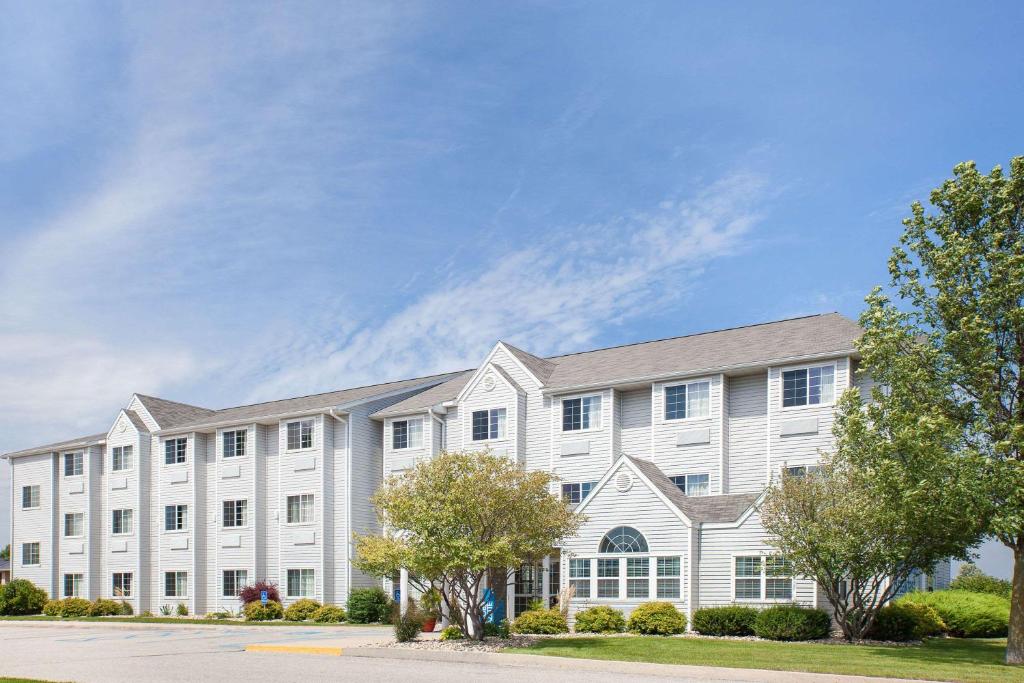 a large white building with trees in front of it at Microtel Inn and Suites Clear Lake in Clear Lake