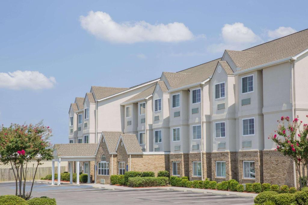 a row of apartment buildings with a parking lot at Microtel Inn & Suites by Wyndham Albertville in Albertville