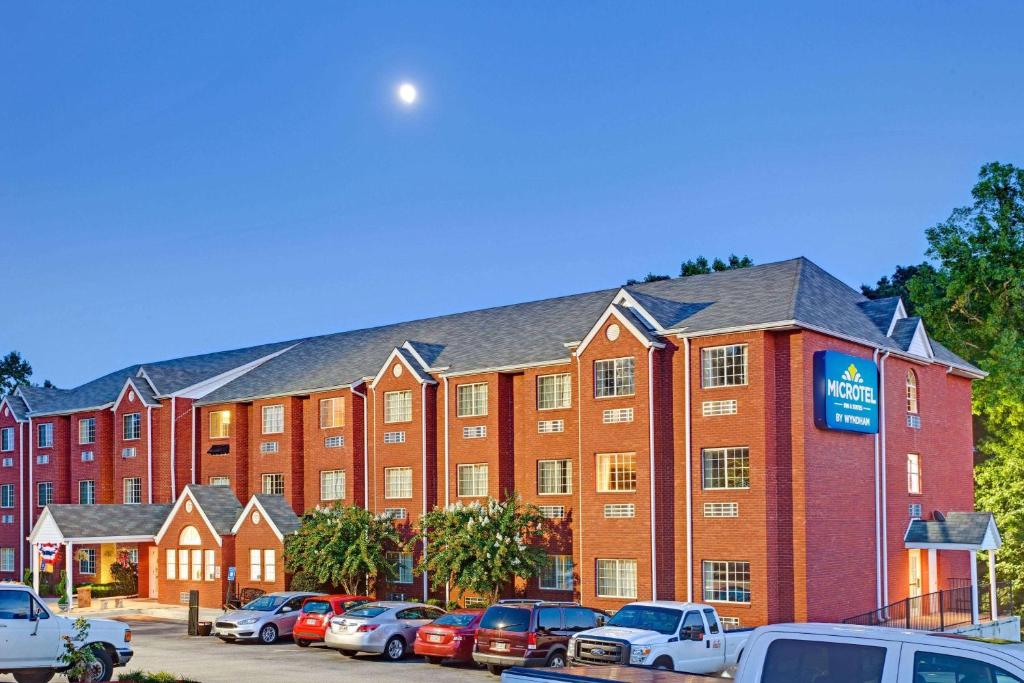 a large red brick building with cars parked in a parking lot at Microtel Inn & Suites by Wyndham Stockbridge/Atlanta I-75 in Stockbridge