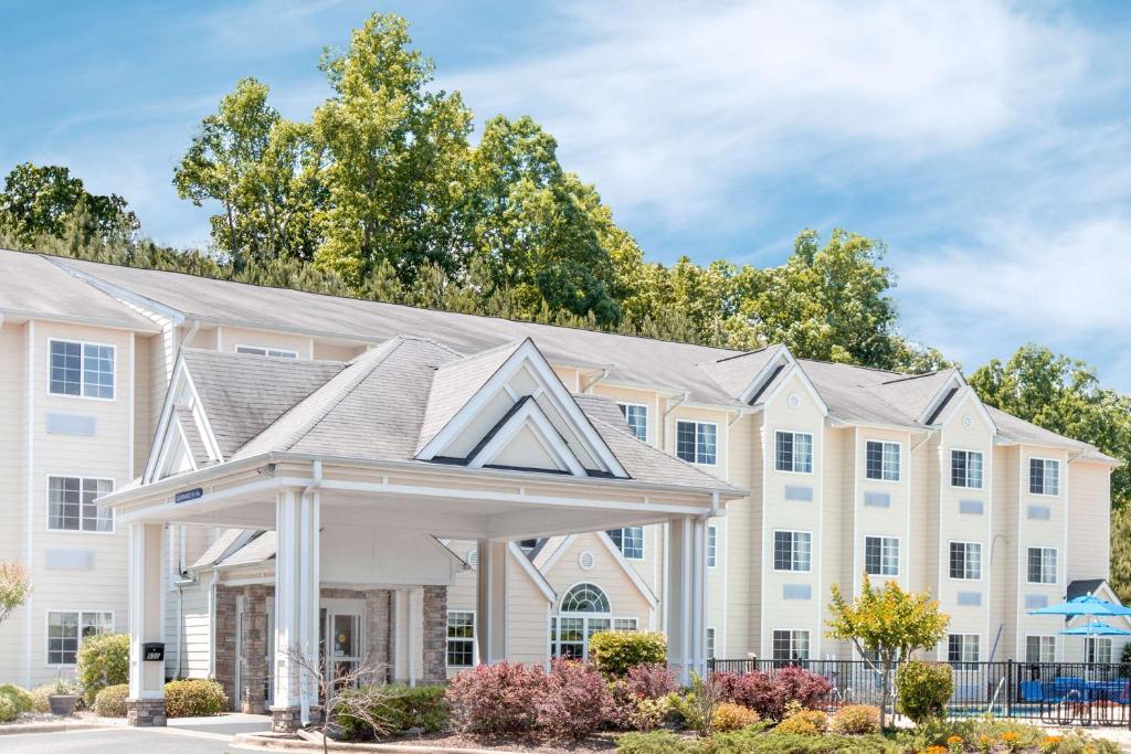 a large white building with a gazebo at Microtel Inn & Suites by Wyndham Gardendale in Gardendale