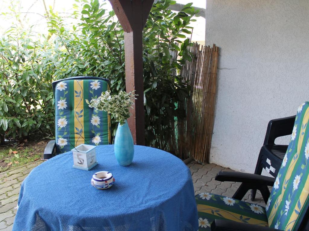 a blue vase sitting on a table with two chairs at Spacious Bungalow near Sea in Grundshagen in Grundshagen
