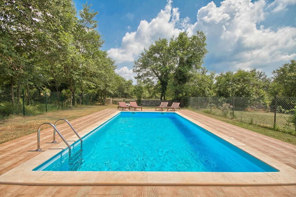 una piscina con acqua blu in un cortile di Villa Postaja a Kanfanar (Canfanaro)