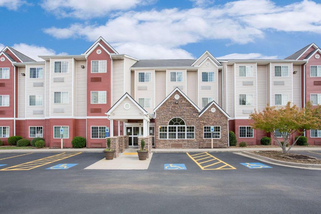 a large building with a parking lot in front of it at Microtel by Wyndham Bentonville in Bentonville
