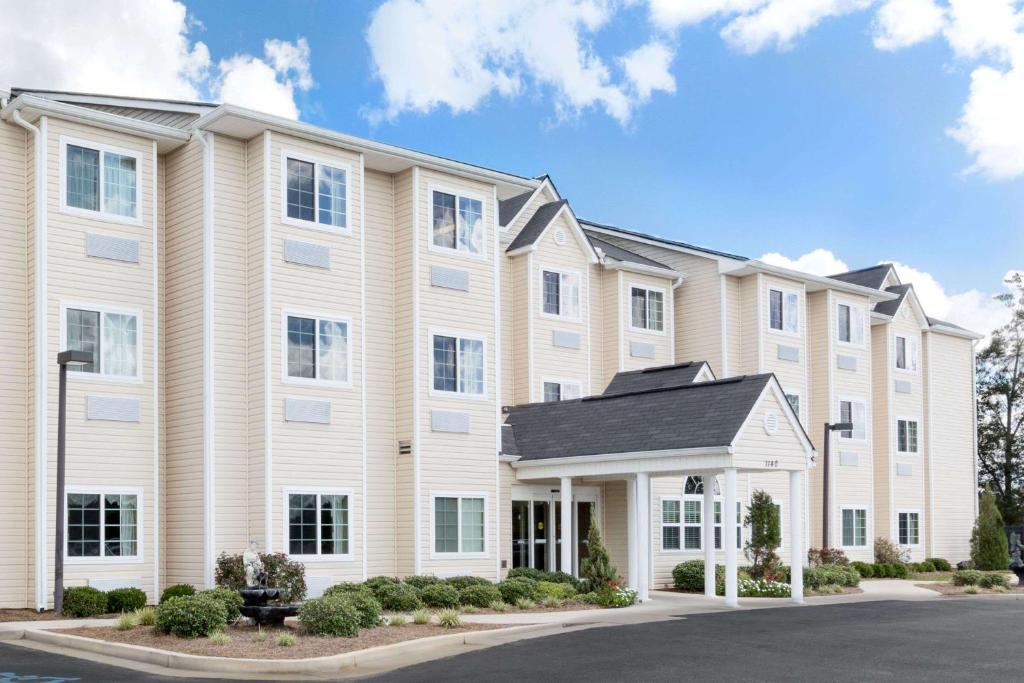 ein großes Apartmenthaus mit Auffahrt in der Unterkunft Microtel Inn & Suites by Wyndham Ozark in Ozark