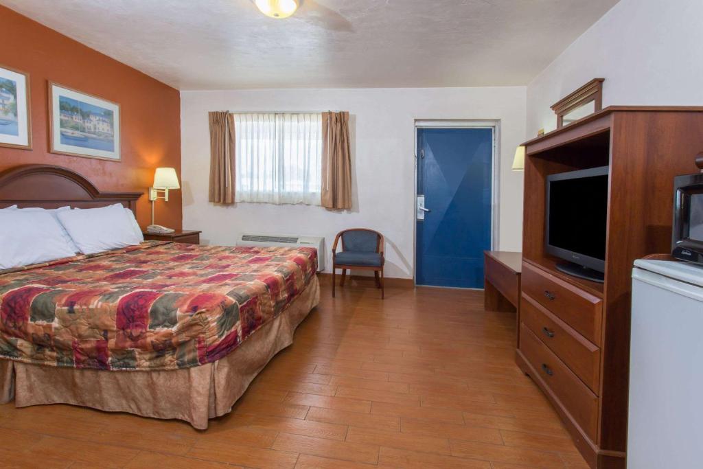 Knights Inn Arcadia في أركاديا: غرفة فندقية بسرير وتلفزيون بشاشة مسطحة