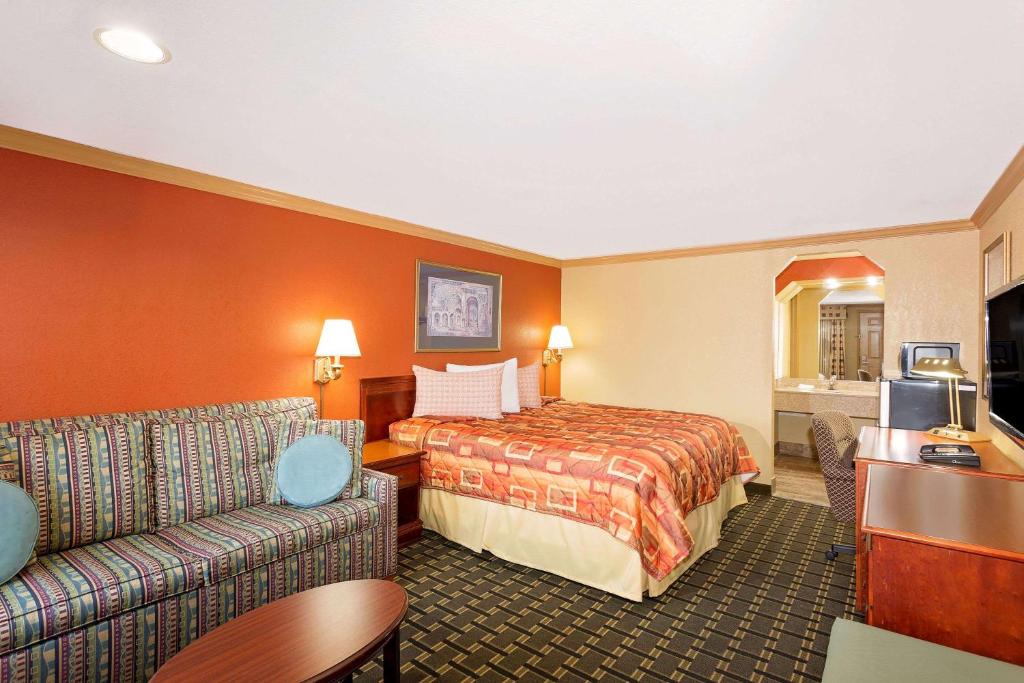 a hotel room with a bed and a couch at Knights Inn Port Charlotte in Port Charlotte