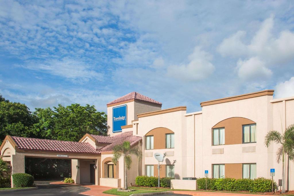 a rendering of a hotel with a building at Travelodge by Wyndham Fort Myers Airport in Fort Myers