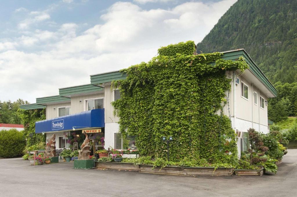 a building covered in ivy next to a mountain at Travelodge by Wyndham Hope in Hope
