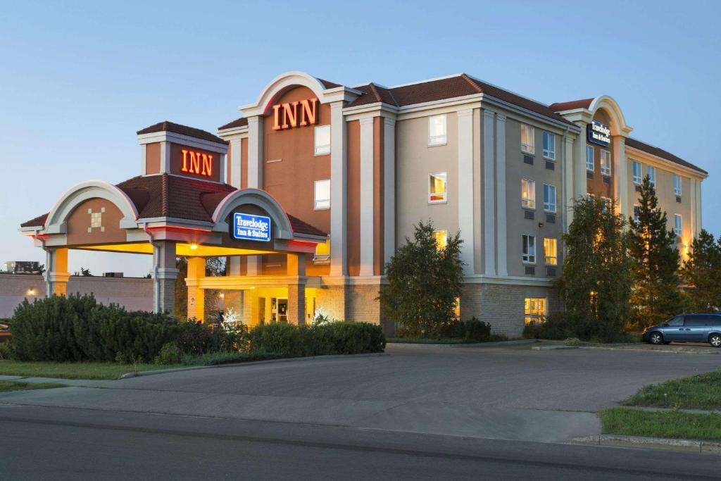 un gran edificio con un coche aparcado delante de él en Travelodge by Wyndham Spruce Grove, en Spruce Grove