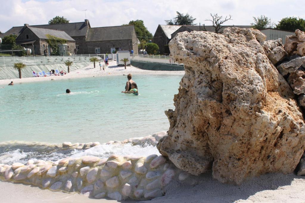 un grupo de personas en el agua en una playa en Camping Pen Guen, en Saint-Cast-le-Guildo