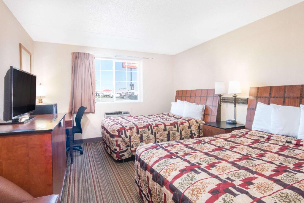 Habitación de hotel con 2 camas y TV de pantalla plana. en Knights Inn and Suites - Grand Forks, en Grand Forks